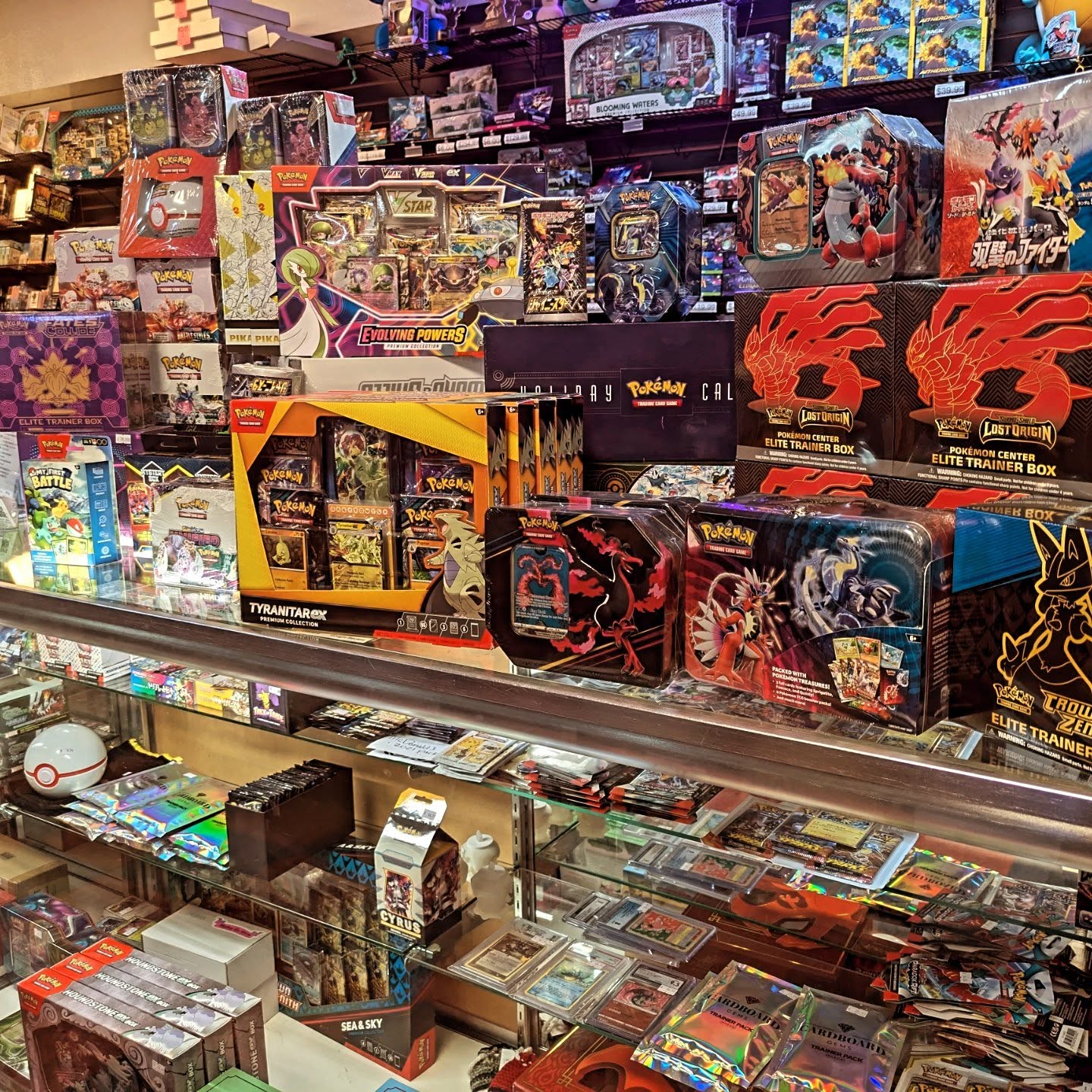 Shelf displaying various trading card game boxes and packs in a store setting.