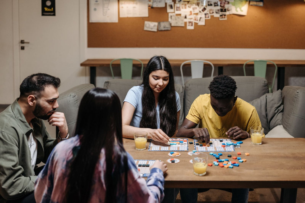 Friends gathered around a table playing a board game