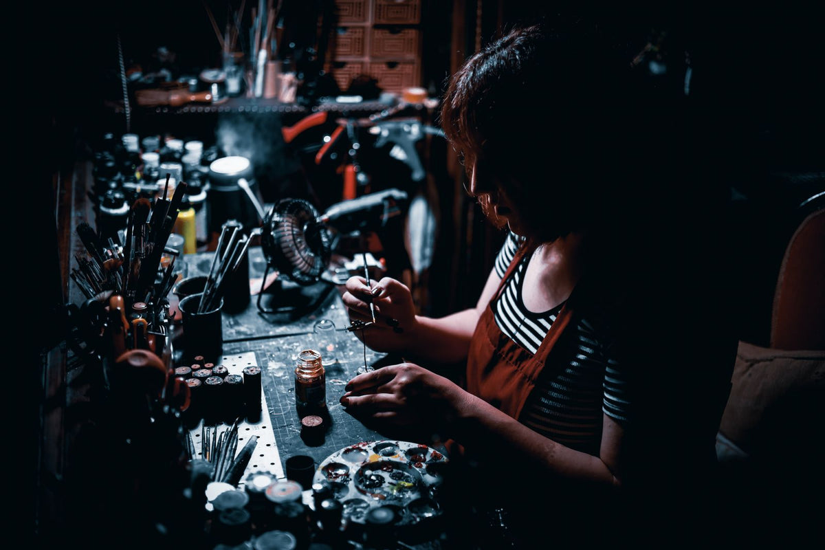 Hobbyist painting a miniature at a workbench